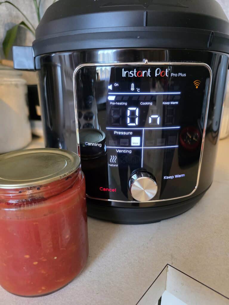 picture of the instant pot pro plus and a jar of tomato not to it