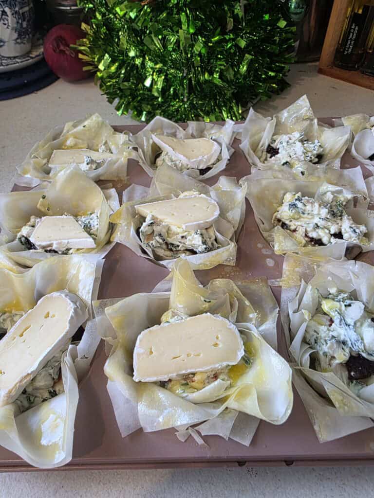 un baked chicken and brie filo tarts sitting in a muffin tray