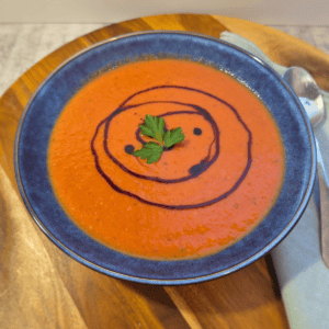 Creamy tomato soup topped with balsamic glaze and fresh herbs
