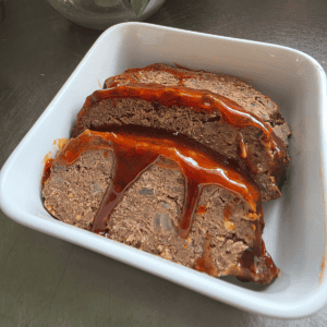 Juicy homemade beef and sausage meatloaf with a sticky tomato sauce topping