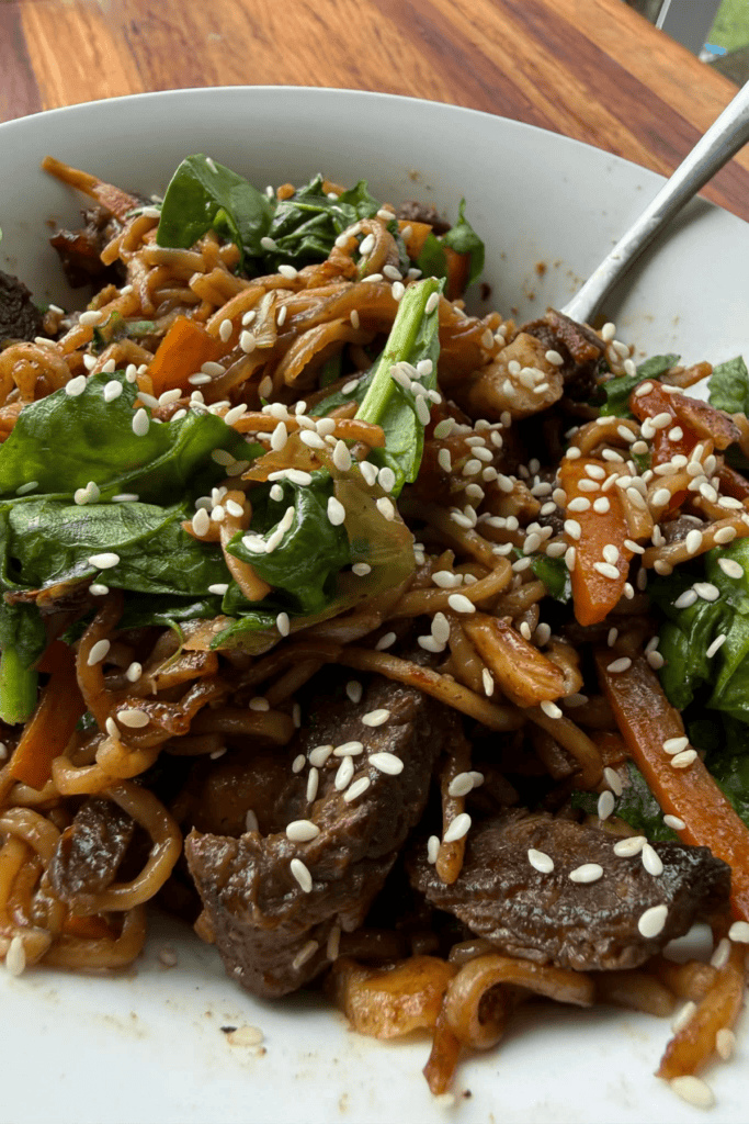 Beef stir fry with egg noodles, mixed vegetables, cashews and sesame seeds