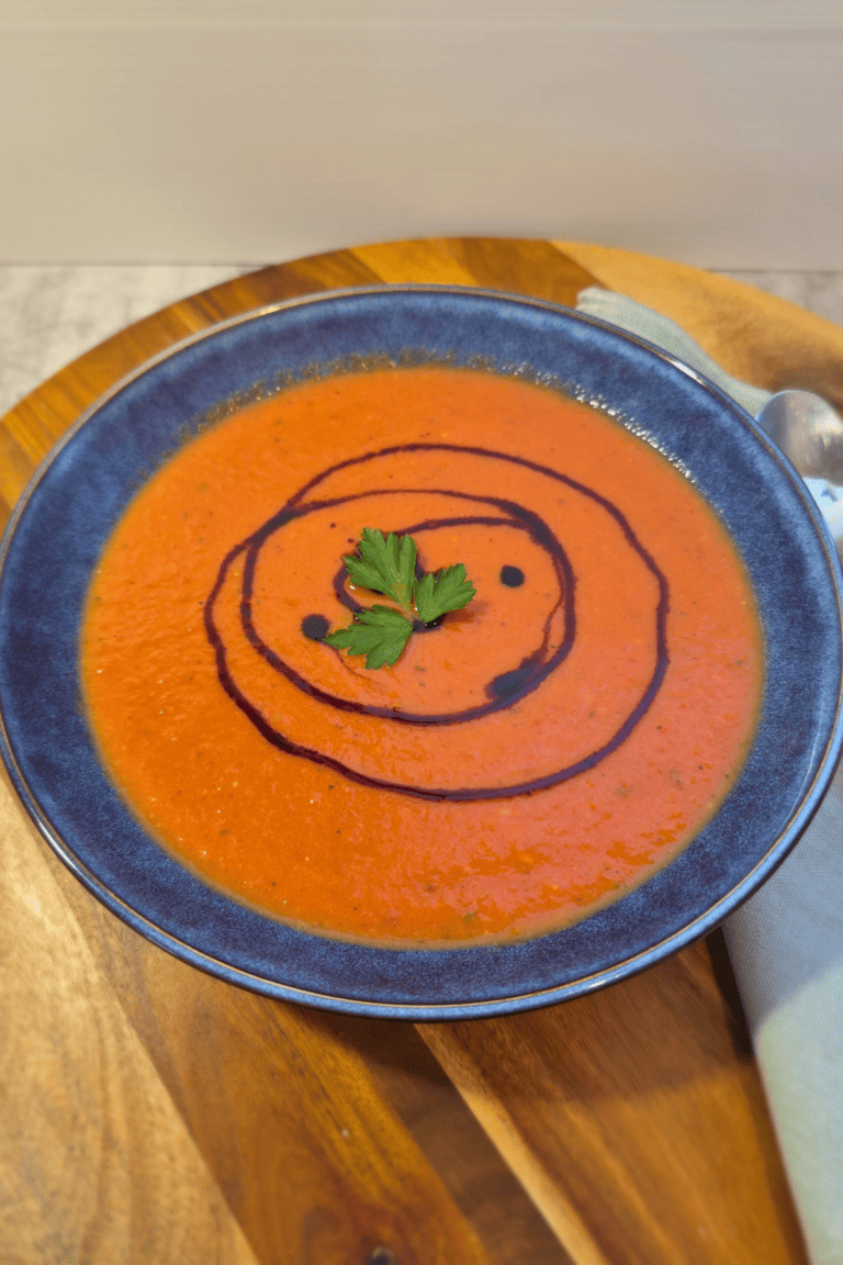 Creamy tomato soup topped with balsamic glaze and fresh herbs